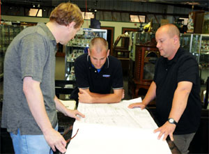Left to right: Tom Sage Jr., chief operating officer; Kris Lee, general manager; and Dan Morphy, owner and CEO of Dan Morphy Auctions examine the architectural plans for the gallery expansion. Dan Morphy Auctions image.