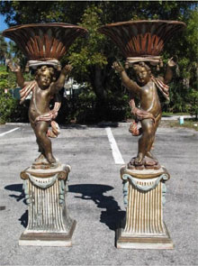 Pair of rare, latter 19th-century Venetian parcel gilt and polychrome painted wood putti, each 57 inches tall and holding a reticulated carved wood cache pot with original tole liners. Estimate for pair $7,000-$9,000. Auctions Neapolitan image.