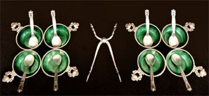 From a Georg Jensen sterling silver flatware set in the Acorn pattern, eight emerald-enameled salts with spoons, and [center] a pair of tongs. Stephenson’s Auctioneers image.
